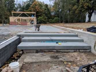 Rockfaced bluestone steps being installed on a masonry base