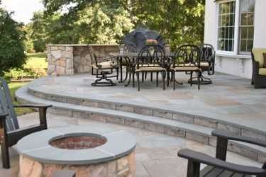 Pennsylvania bluestone pattern flagging patio with a stone seat wall and fire pit